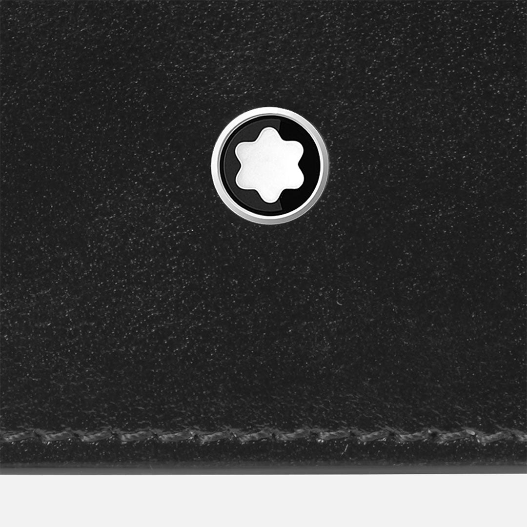 Close-up of the Montblanc Meisterstuck 6CC Leather Wallet by Montblanc, showing its black leather surface, silver and white star-shaped emblem in the center, and visible stitching along the bottom edge.