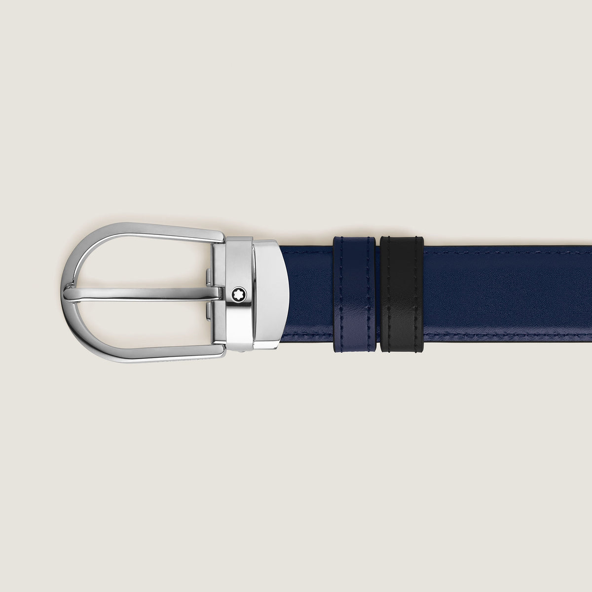 A close-up of the Montblanc Horseshoe Buckle 30mm Reversible Black and Ink Blue Leather Belt, featuring black loops and a silver buckle, displayed on a plain light background.