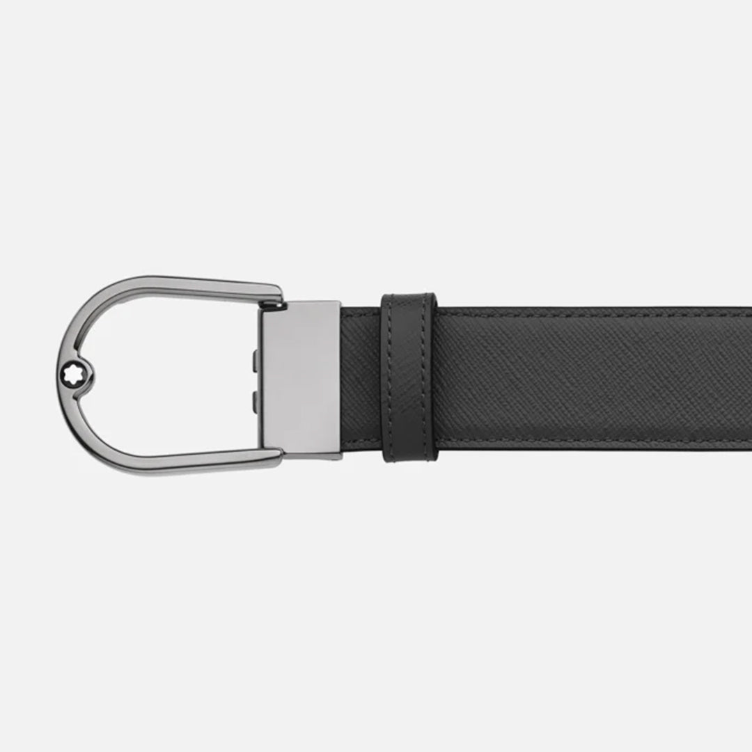 The Montblanc Horseshoe Buckle Saffiano Printed Mastic 35mm Reversible Leather Belt features a metallic, uniquely shaped buckle with a small Montblanc emblem and is shown horizontally on a light gray background.