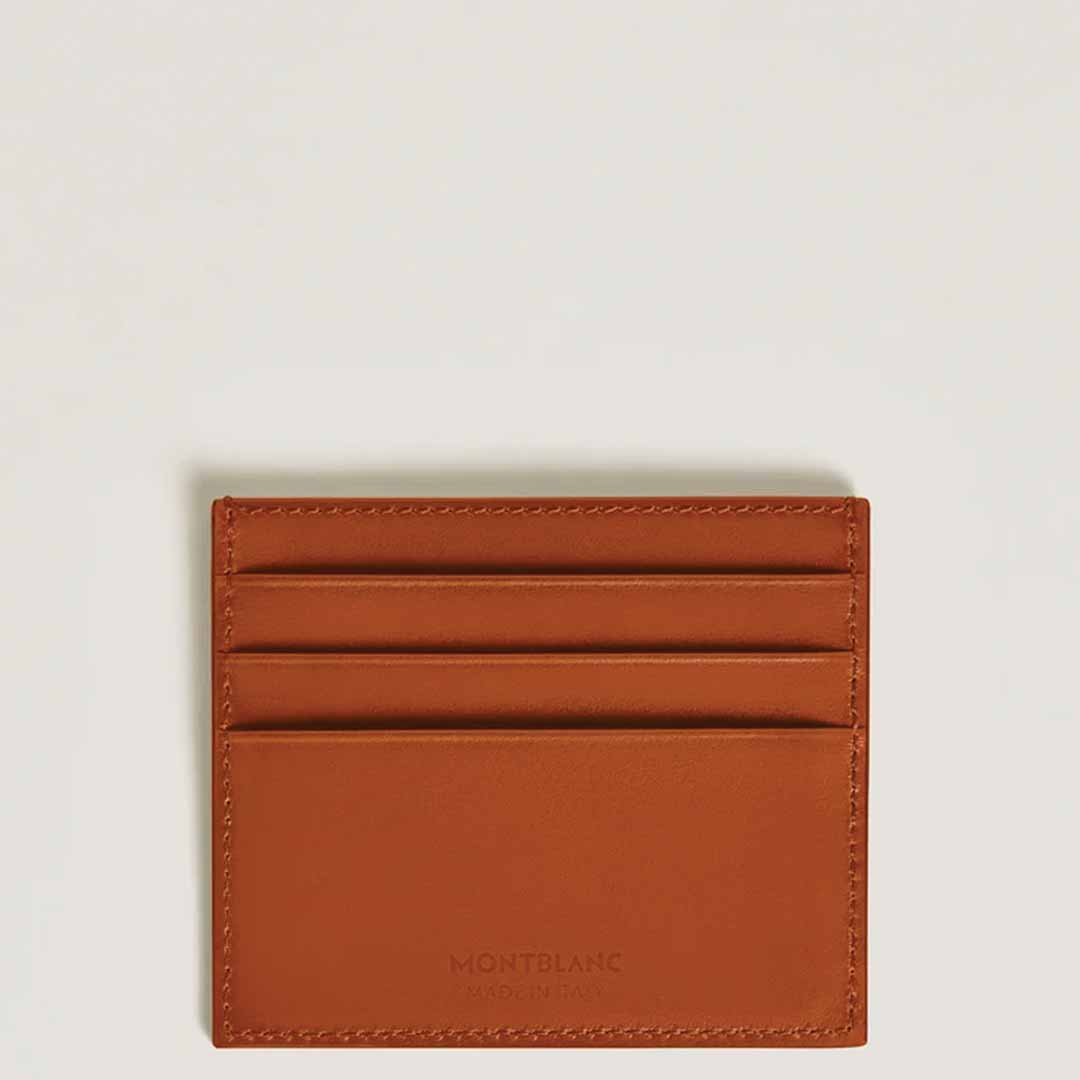 The Montblanc Meisterstück 6cc Leather Card Holder, made from brown leather, includes three slots and is adorned with an embossed Montblanc emblem at the bottom center. It is showcased beautifully against a light, neutral background.