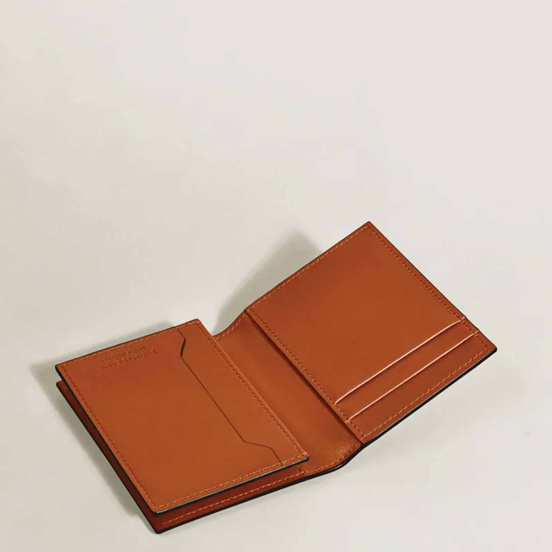 A Montblanc Meisterstuck 4cc Leather Card Holder in brown is open, showcasing multiple card holder slots on one side and a pocket on the other, all set against a plain white background.