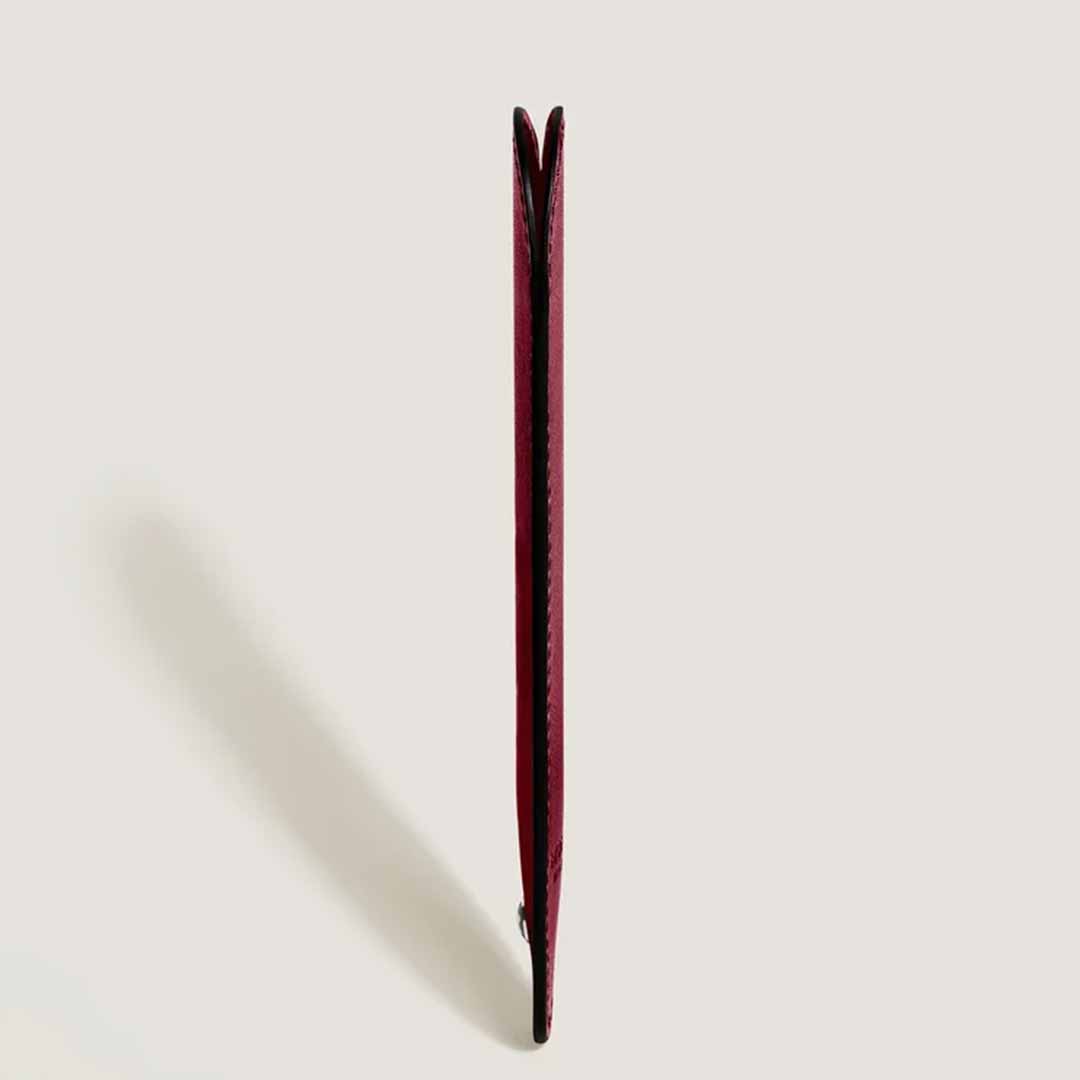 The Montblanc Sartorial Single Writing Instrument Sleeve is a red accessory crafted from Saffiano leather, featuring a textured yet smooth surface. It has a rounded top with a tapered bottom and displays a small white emblem near the base.