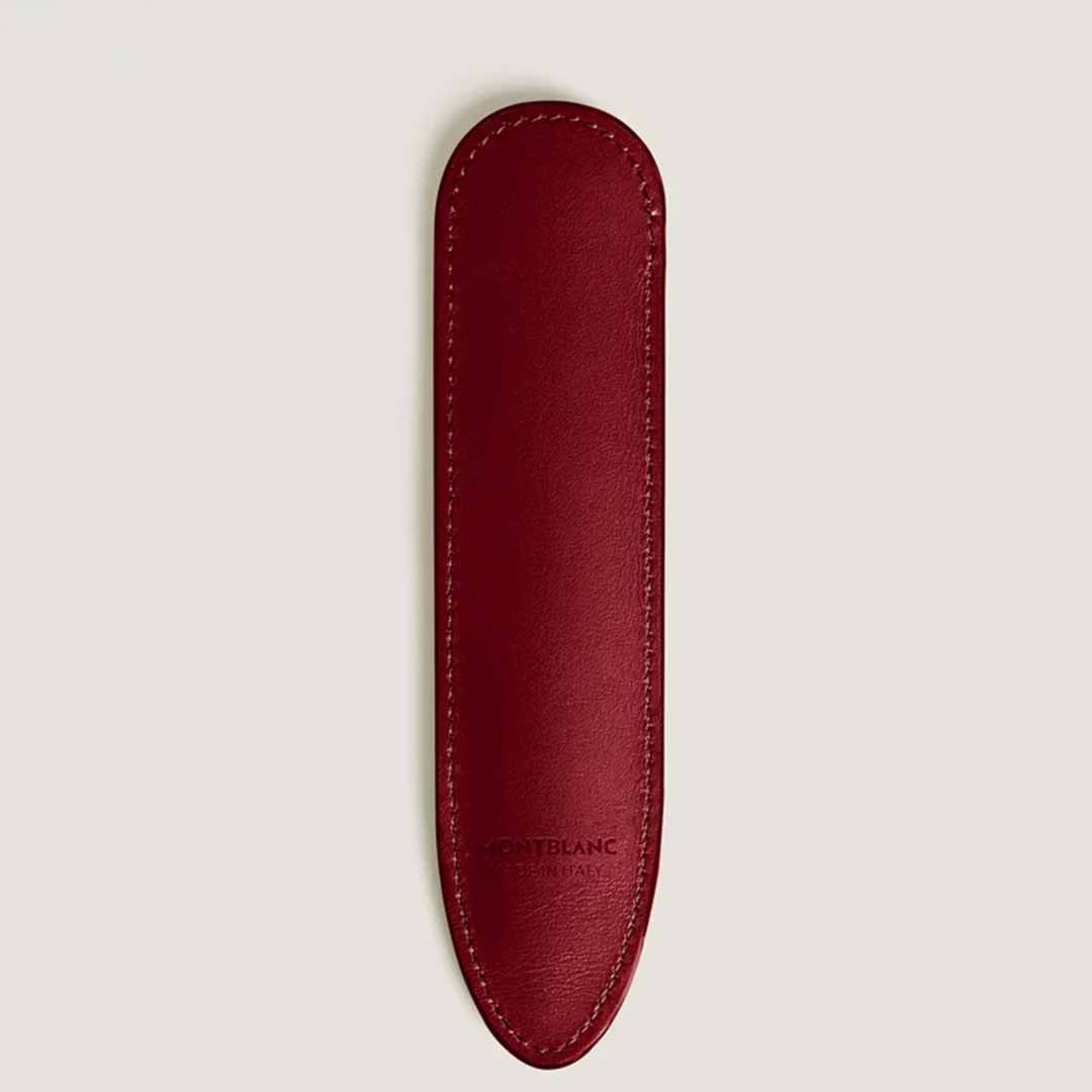 The Montblanc Sartorial Single Writing Instrument Sleeve is a red accessory crafted from Saffiano leather, featuring a textured yet smooth surface. It has a rounded top with a tapered bottom and displays a small white emblem near the base.