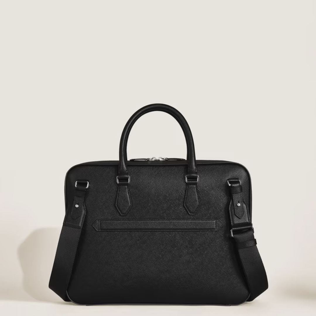 The Montblanc Sartorial Medium Leather Document Case Bag features a sleek black design with two handles, a detachable shoulder strap, and minimal detailing, shown against a plain light background.