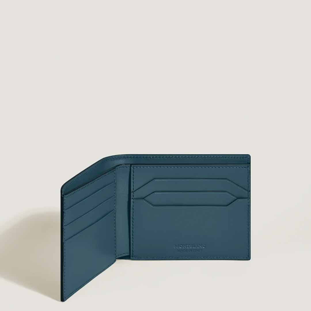 A Montblanc Extreme 3.0 6cc Leather Wallet in teal leather is open, showcasing card slots on the left side and a central pocket embossed with the distinctive Montblanc emblem. The simple off-white background enhances the wallet's sophisticated design.