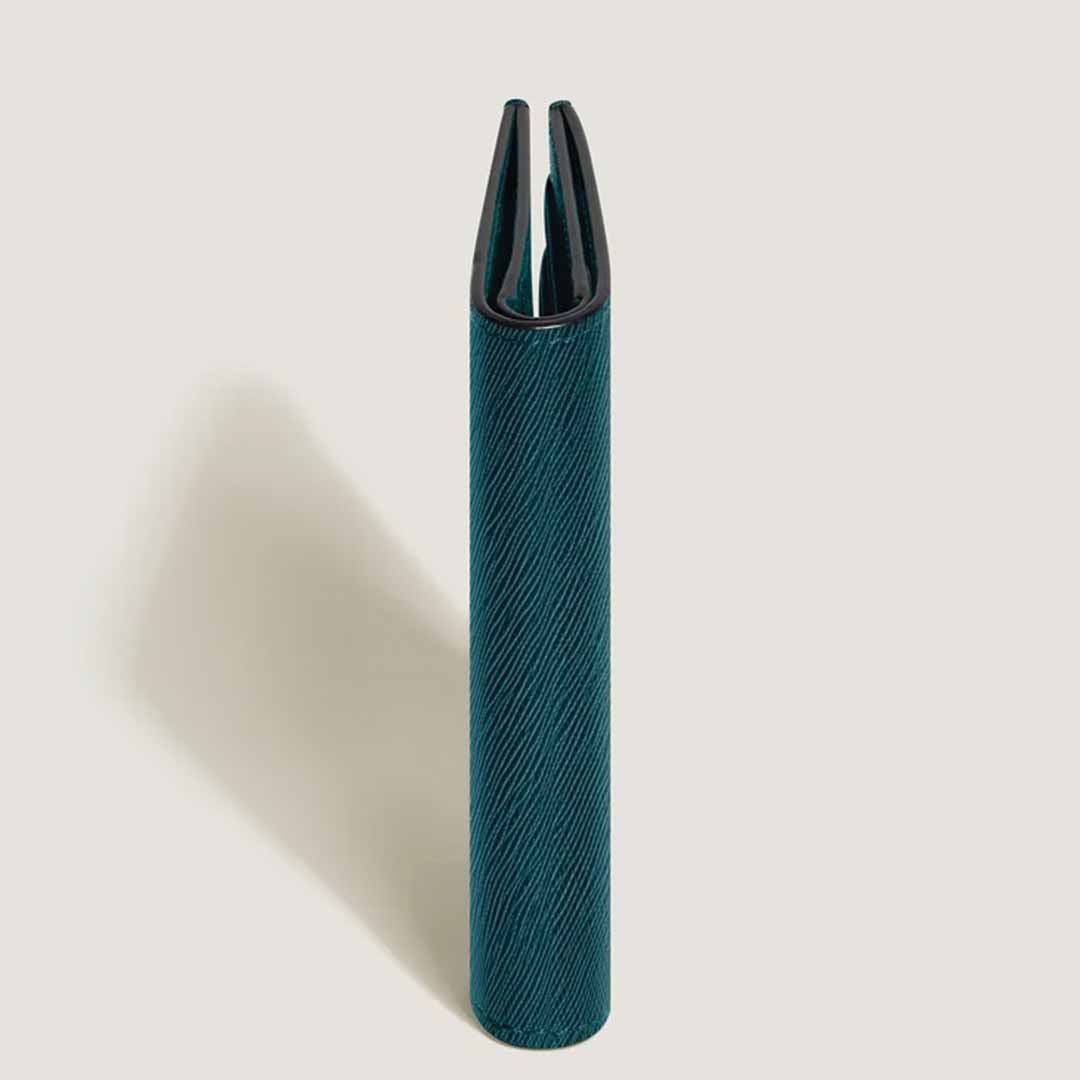A Montblanc Sartorial 4cc Mini Leather Wallet in elegant Cyprus blue leather stands upright against a light background, with its open end facing up and casting a gentle shadow to the side.