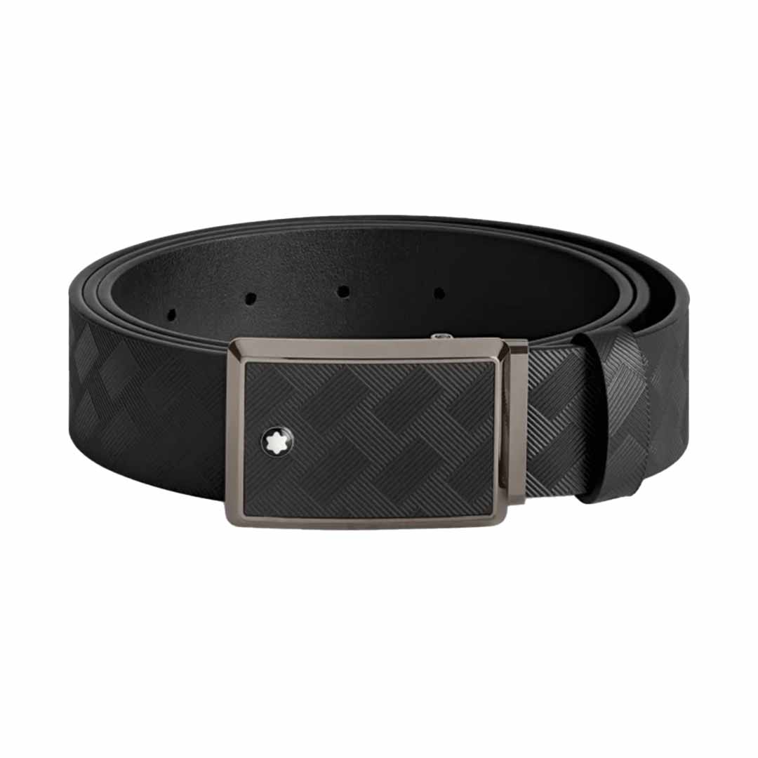 The Montblanc 35mm Leather Belt, crafted by Montblanc, features a black leather design with a textured checkered pattern and a rectangular metallic buckle adorned with a shiny ruthenium finish, coiled in a circular shape.