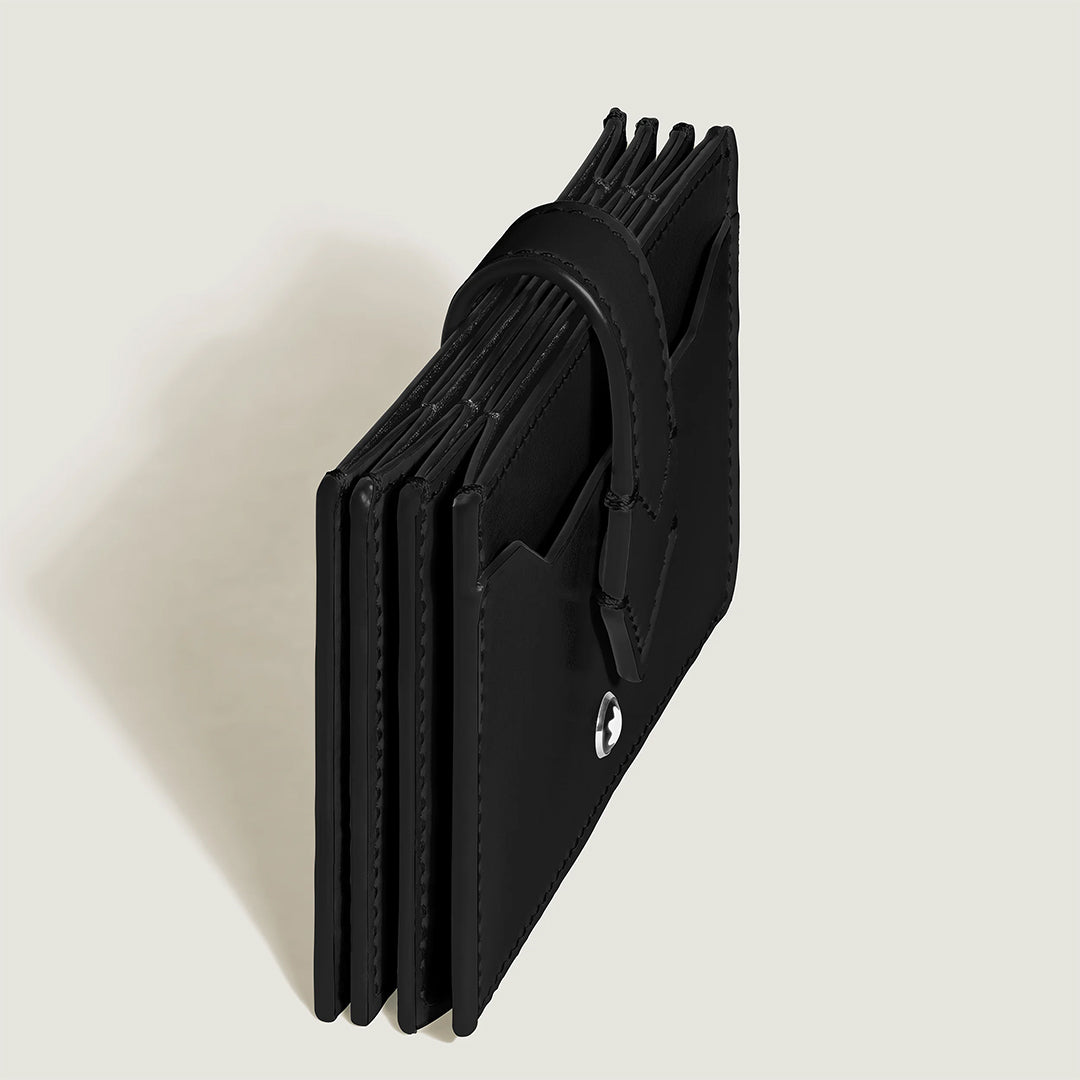 The Montblanc Meisterstück 5CC Card Holder features a sleek black leather design with multiple slots and a small Montblanc logo in the corner. The open wallet displays its compartments, casting a subtle shadow on a light, neutral background.