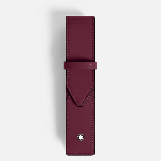 The Montblanc Meisterstück 1-Pen Pouch is a handcrafted burgundy leather accessory with a flap closure, featuring a small round metal emblem near the bottom. Its minimalist design reflects the classic style against a light gray background.