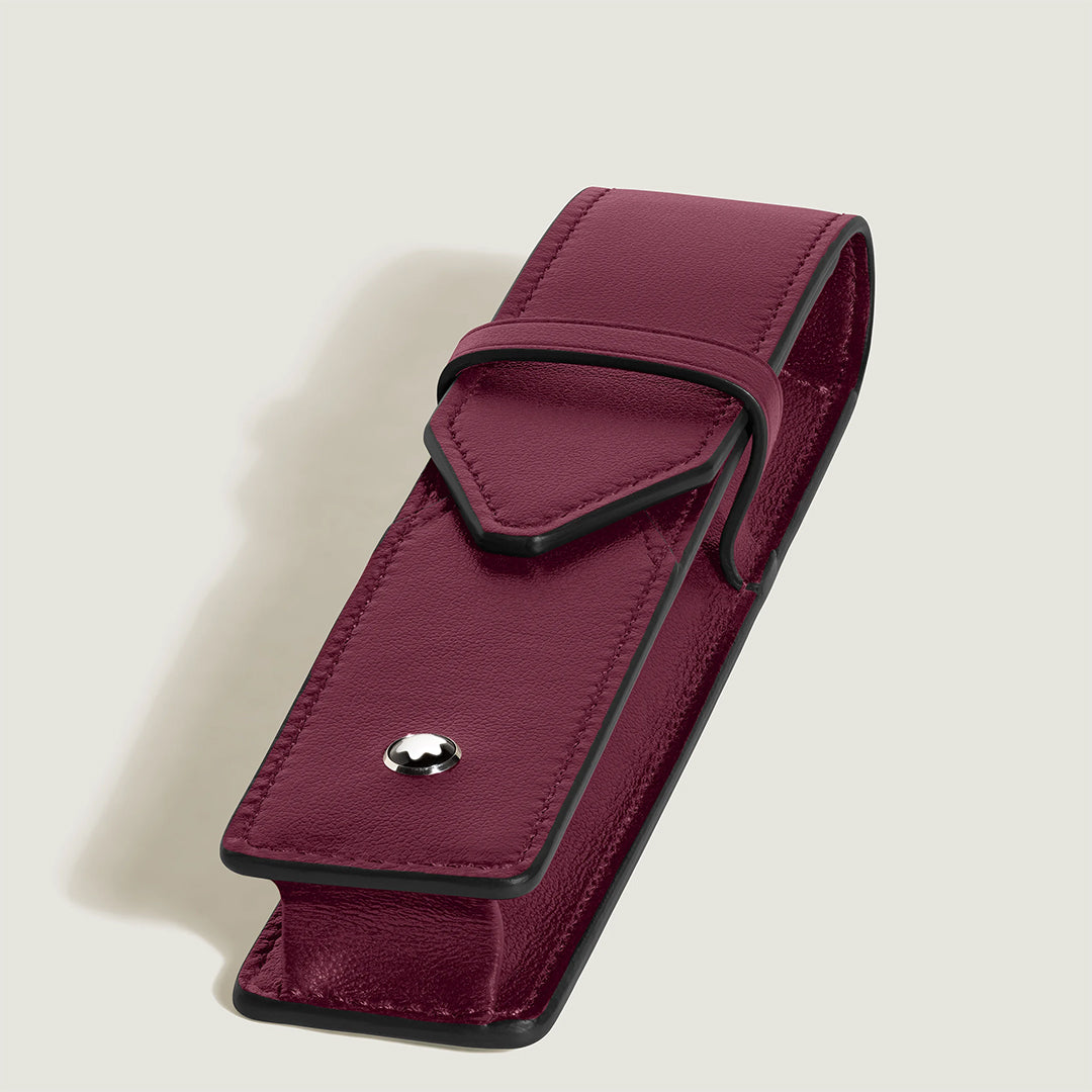 This exquisite Montblanc Meisterstück 1-Pen Pouch showcases a handcrafted burgundy leather case with black edges, featuring a secure fold-over flap with a metal stud closure against a light gray backdrop.