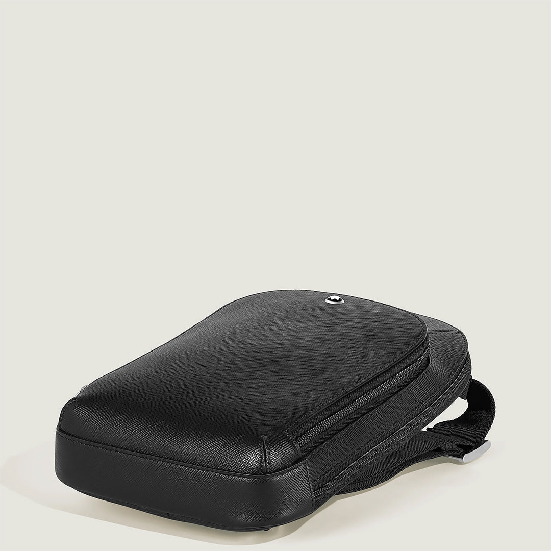 The Montblanc Sartorial Sling Bag is a sleek black pouch crafted from saffiano-embossed leather with a smooth texture, featuring a secure zipper closure and a subtle front logo. Positioned against an off-white background, it highlights its elegant and minimalist design.