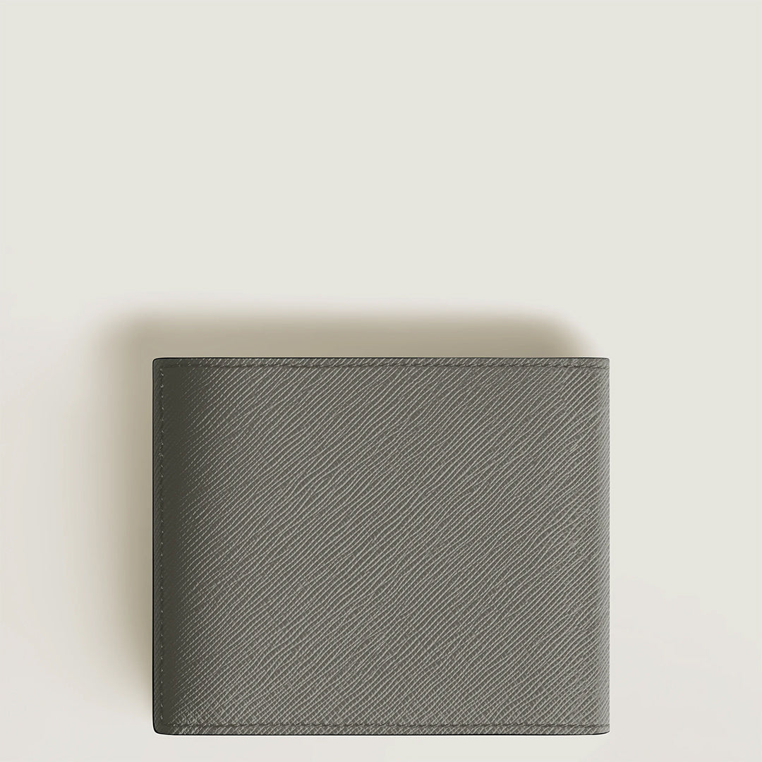 The Montblanc Sartorial 8CC Leather Wallet, featuring a dark gray Saffiano print and textured diagonal pattern, rests closed in its compact form on a light, plain surface.
