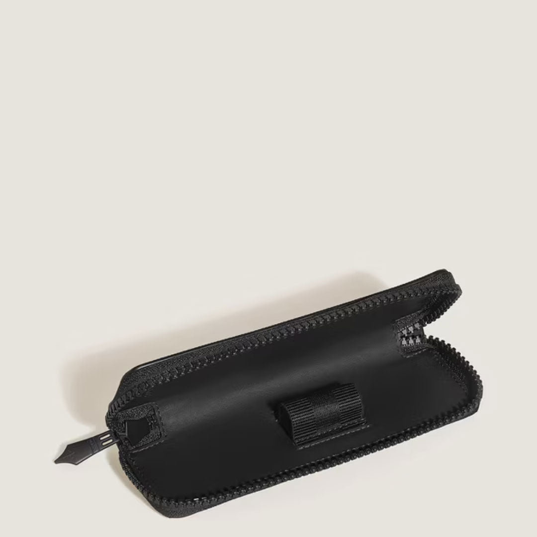 The Montblanc Extreme 3.0 Black Leather Single Pen Pouch is shown open on a light background, with a pen loop visible inside and the zipper partially unzipped along the edge.