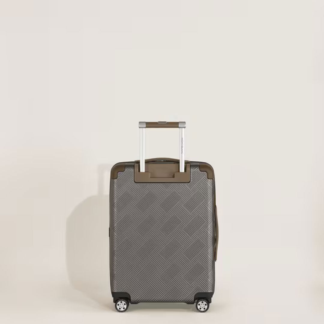 The Montblanc Extreme 3.0 Cabin Luggage with Pocket, a gray polycarbonate trolley with textured pattern, TSA lock, telescopic handle, and four wheels, stands upright against a plain light background.