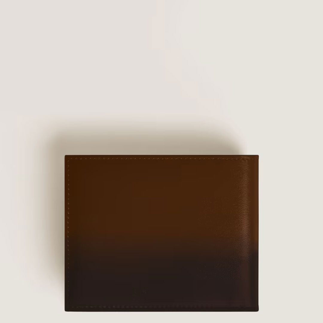 The Montblanc Meisterstück Sfumato 6CC Leather Wallet in brown, crafted by Montblanc, is shown closed with minimal stitching on a light surface, elegantly presented from a top-down view.