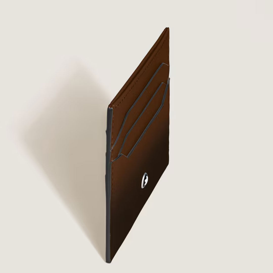 The Montblanc Meisterstück 6CC Leather Card Holder, crafted in Sfumato Brown with two card slots and a silver logo, is shown upright against a light beige background.