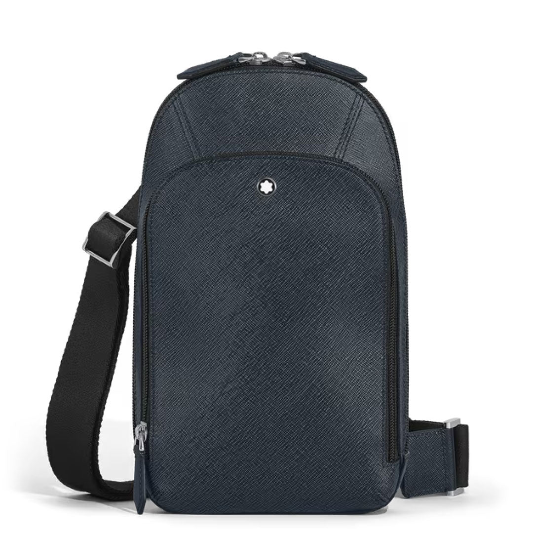 The Montblanc Sartorial Leather Sling Bag features dark blue textured leather, an adjustable shoulder strap, front zipper pocket, and a small round Montblanc logo near the top center.