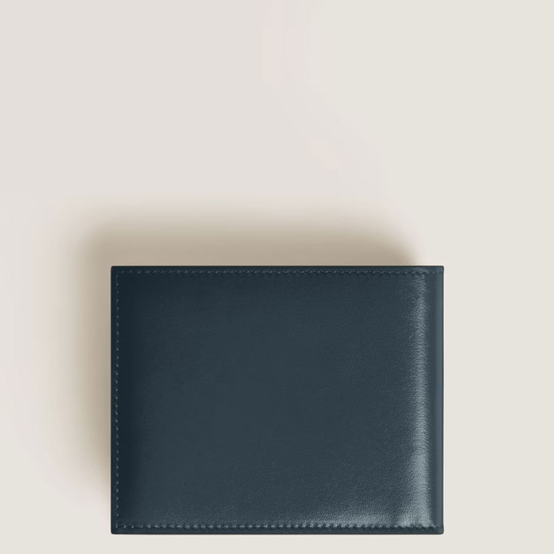 A closed Montblanc Meisterstuck 6CC Leather Wallet is placed on a light beige surface and photographed from above.