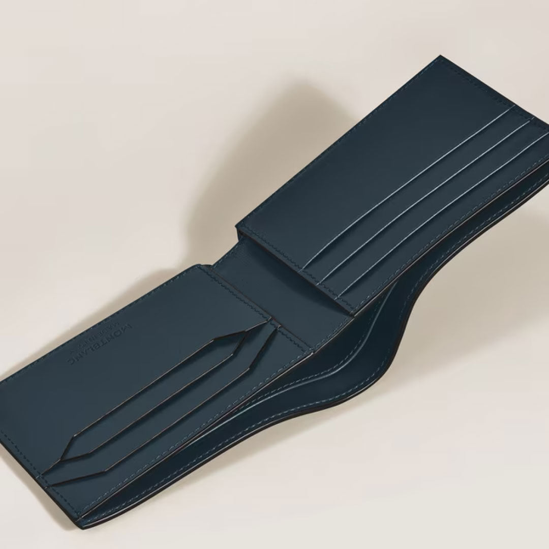 The Montblanc Meisterstuck 6CC Leather Wallet by Montblanc, in dark blue, is open on a light beige background, displaying multiple card slots and compartments.