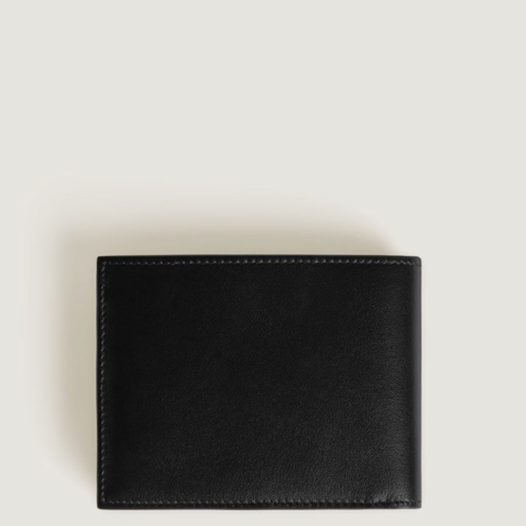 A closed Montblanc Meisterstuck 6CC Leather Wallet in black leather with visible stitching rests on a plain, light-colored surface.