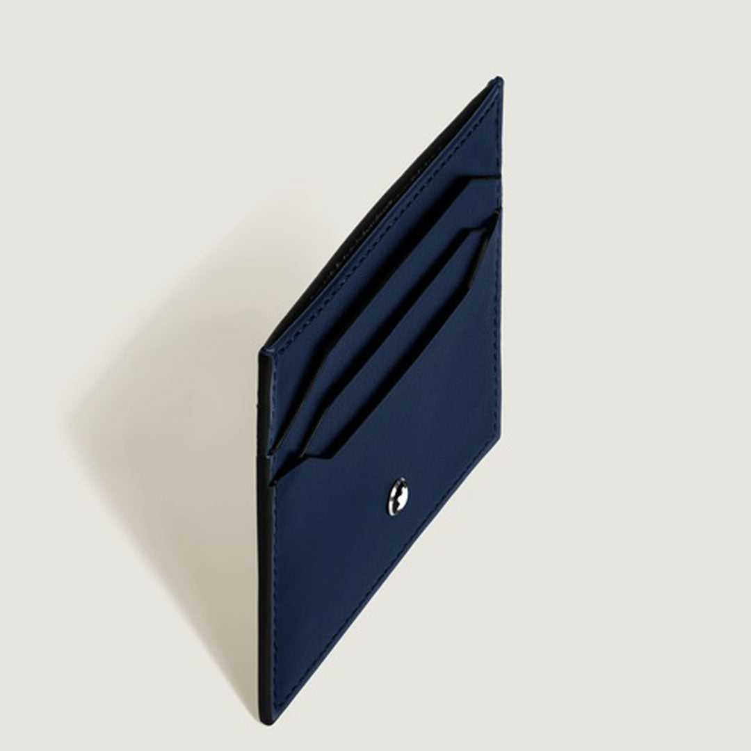 The Montblanc Meisterstuck 6CC Leather Card Holder is a minimalist navy blue card holder with two slots and a round silver logo on the front, crafted from supple calfskin and shown upright against a plain light background.