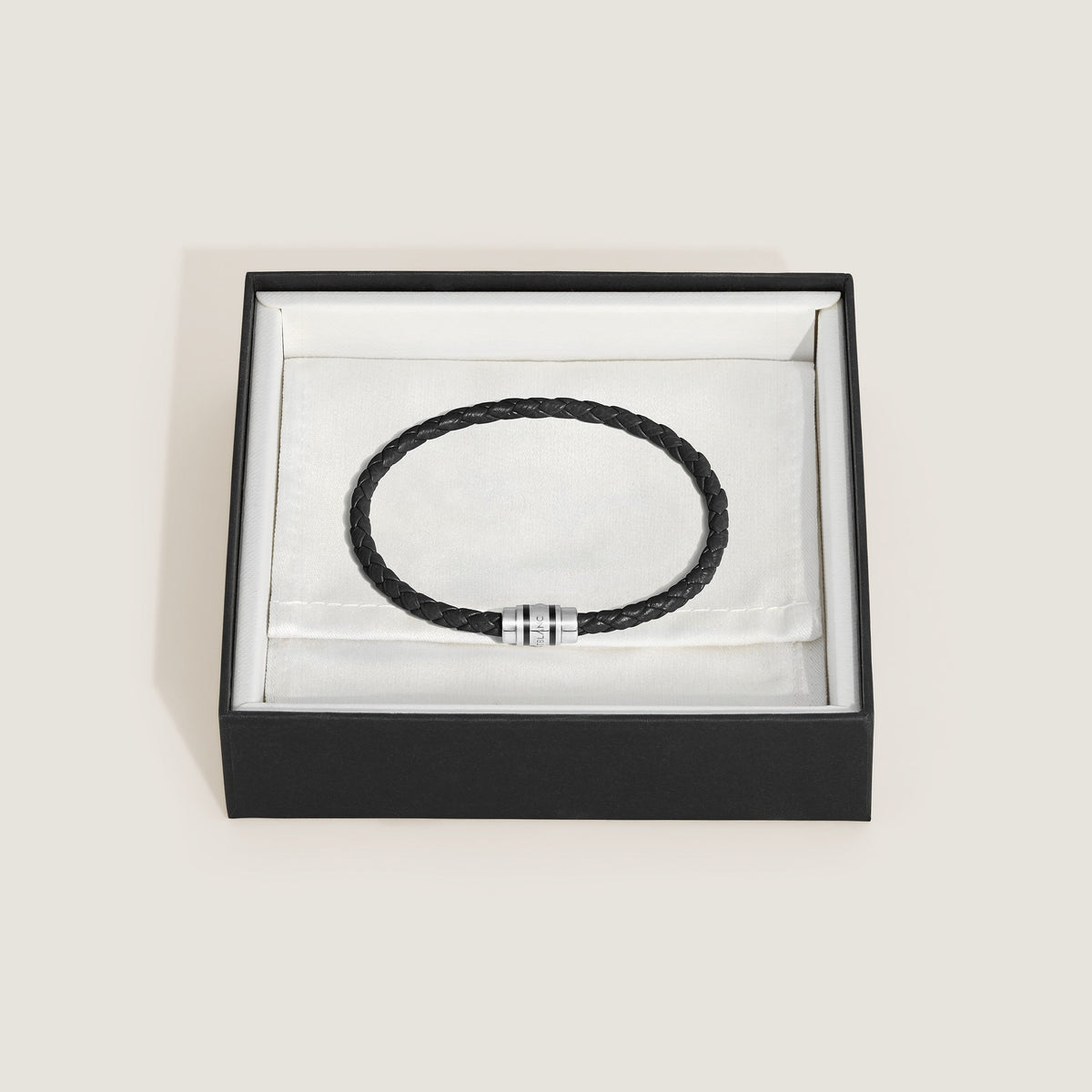 The Montblanc 3 Rings Black Grain Leather Bracelet features a sleek silver clasp and comes elegantly packaged in a black and white gift box lined with white fabric.