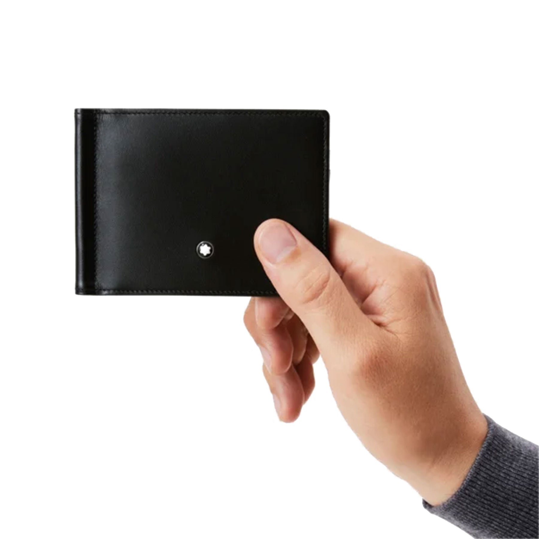 In the hand, a sleek Montblanc Meisterstück Black Leather Wallet crafted from full-grain cowhide showcases its refined design, with a small round metal emblem. The minimalistic elegance radiates quality against the subtle backdrop of the person's long-sleeve gray shirt.