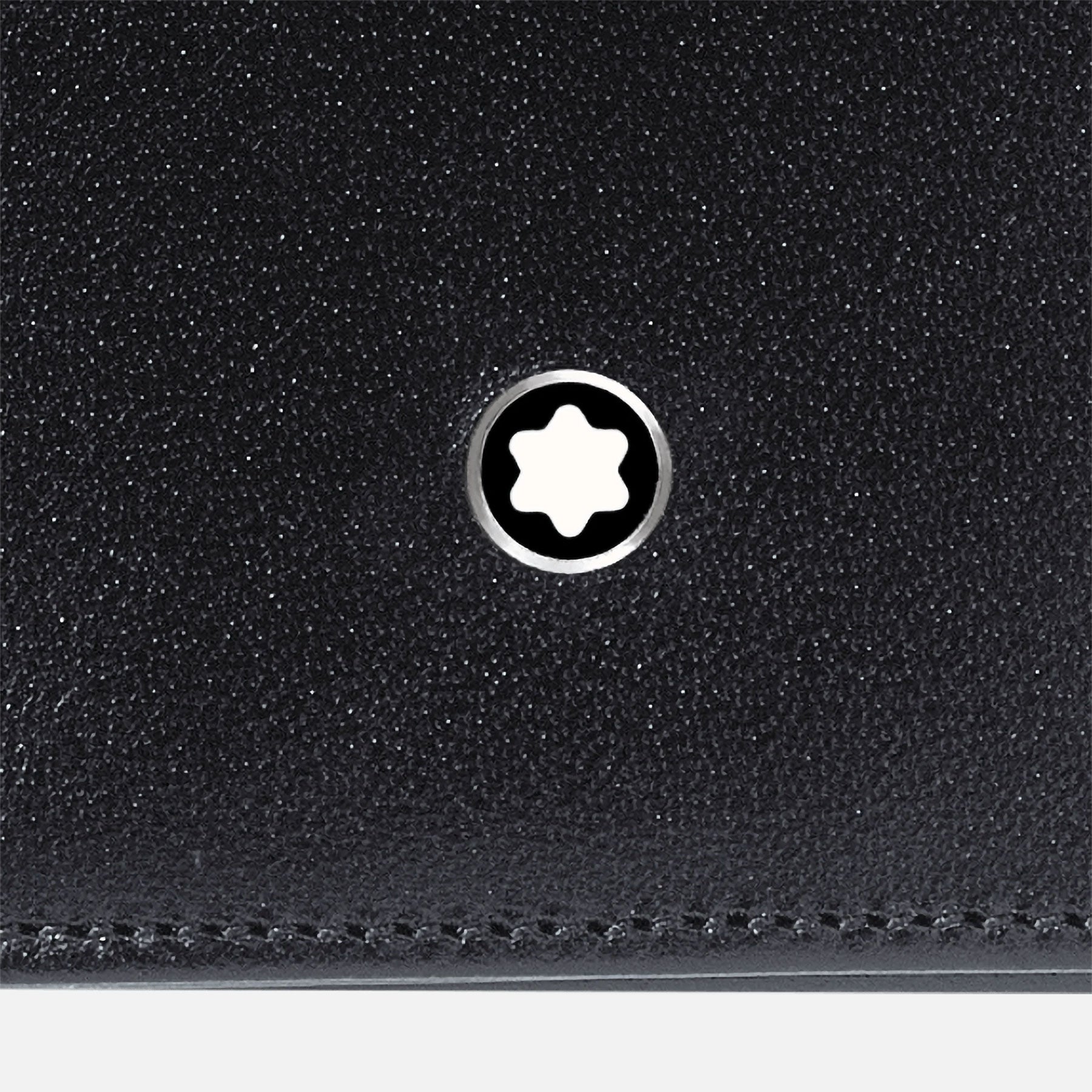 Close-up of the Montblanc Meisterstück 14cc Leather, a black cowhide wallet showcasing the iconic six-pointed white star emblem set in a metallic ring. Its smooth and polished texture harmonizes elegantly with its interior credit card pockets.