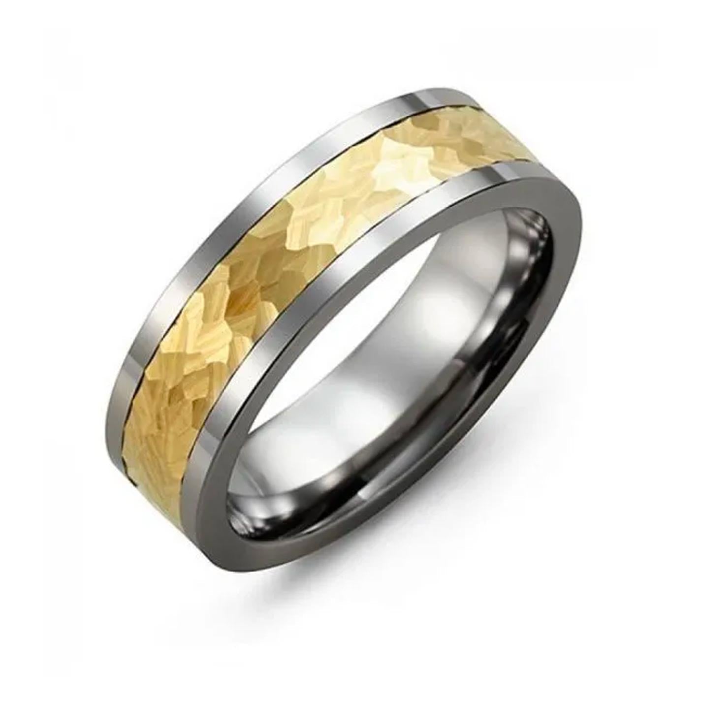 The Madani Hammer Effect Tungsten and 10K Yellow Gold Wedding Band exudes masculine jewelry appeal with its polished silver appearance and a textured, hammered gold band at the center. The contrast between the silver and gold highlights the intricate design, making it a captivating piece. Displayed on a plain white background, this ring stands out beautifully.