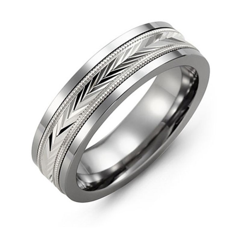 The Madani Tungsten and 10K White Gold Wedding Band, by Madani, showcases a sleek silver tungsten design adorned with a decorative chevron pattern and milgrain detailing along the edges. The ring features a polished finish reminiscent of a diamond-cut wedding band.