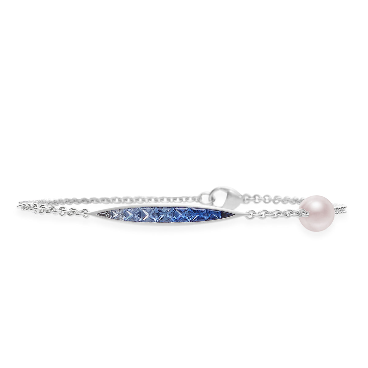 The Mikimoto Ocean Collection 18k White Gold Sapphire with Akoya Cultured Pearl Bracelet highlights a finely crafted 18 karat white gold design adorned with a central bar of gradient blue sapphires, transitioning from light to dark. An exquisite round Akoya pearl near the clasp enhances the elegance of this piece.