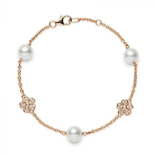 The Mikimoto Cherry Blossom bracelet is crafted from 18K rose gold and showcases two Akoya cultured pearls along with two flower-shaped crystal embellishments, all secured with a lobster clasp.