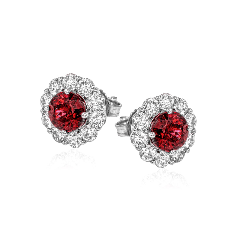 Introducing the Simon G. 18K White Gold Diamond and Ruby Stud Earrings, an exquisite pair designed by Simon G. These elegant earrings feature vibrant round red rubies at the center, encircled by a halo of dazzling clear diamonds, all exquisitely set in a luxurious white gold setting with a classic stud design.