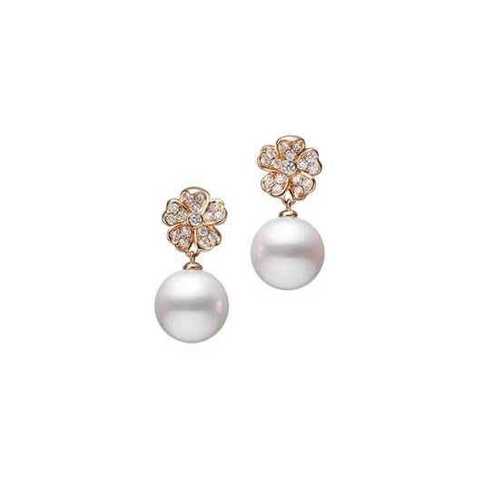 Photographed against a plain white background, the Mikimoto Cherry Blossom Stud Earrings elegantly showcase Akoya cultured pearl pendants suspended from 18k rose gold floral-shaped studs, accented with delicate diamonds.
