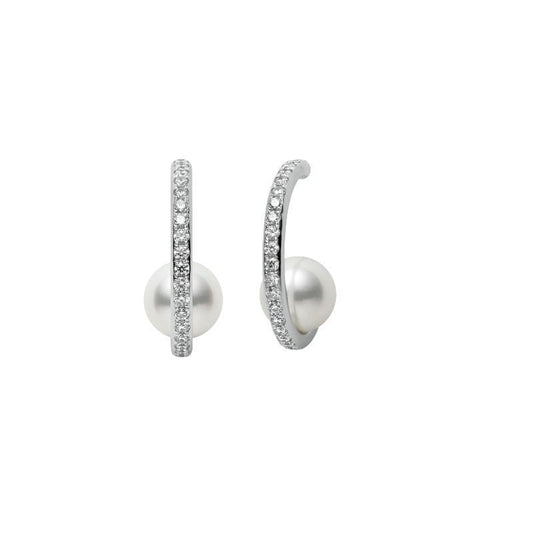 The Mikimoto 18k White Gold Akoya Cultured Pearl and Diamond Hoop Earrings feature a classic design with shimmering diamonds lining the front, each centered with a large cultured pearl. This elegant brand, Mikimoto, presents these exquisite earrings against a plain white background.