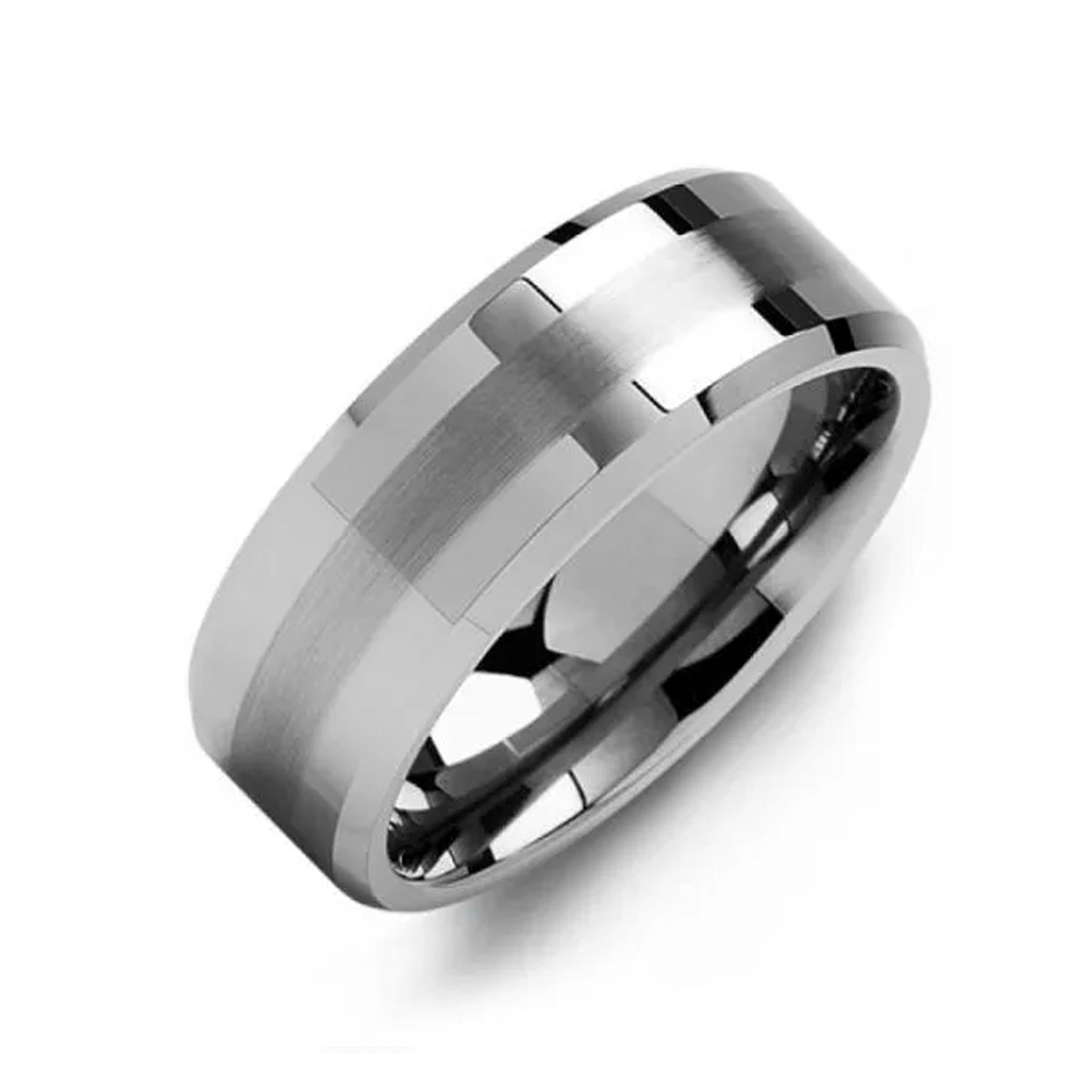 Introducing the Madani Dual Beveled Finish Tungsten Wedding Band, a modern and sophisticated accessory. This sleek silver ring features beveled edges and a polished finish adorned with geometric accents. Its slightly rounded design is enhanced by a satin centerpiece, all elegantly presented against a plain white background. Made by Madani, this band exemplifies style and refinement.