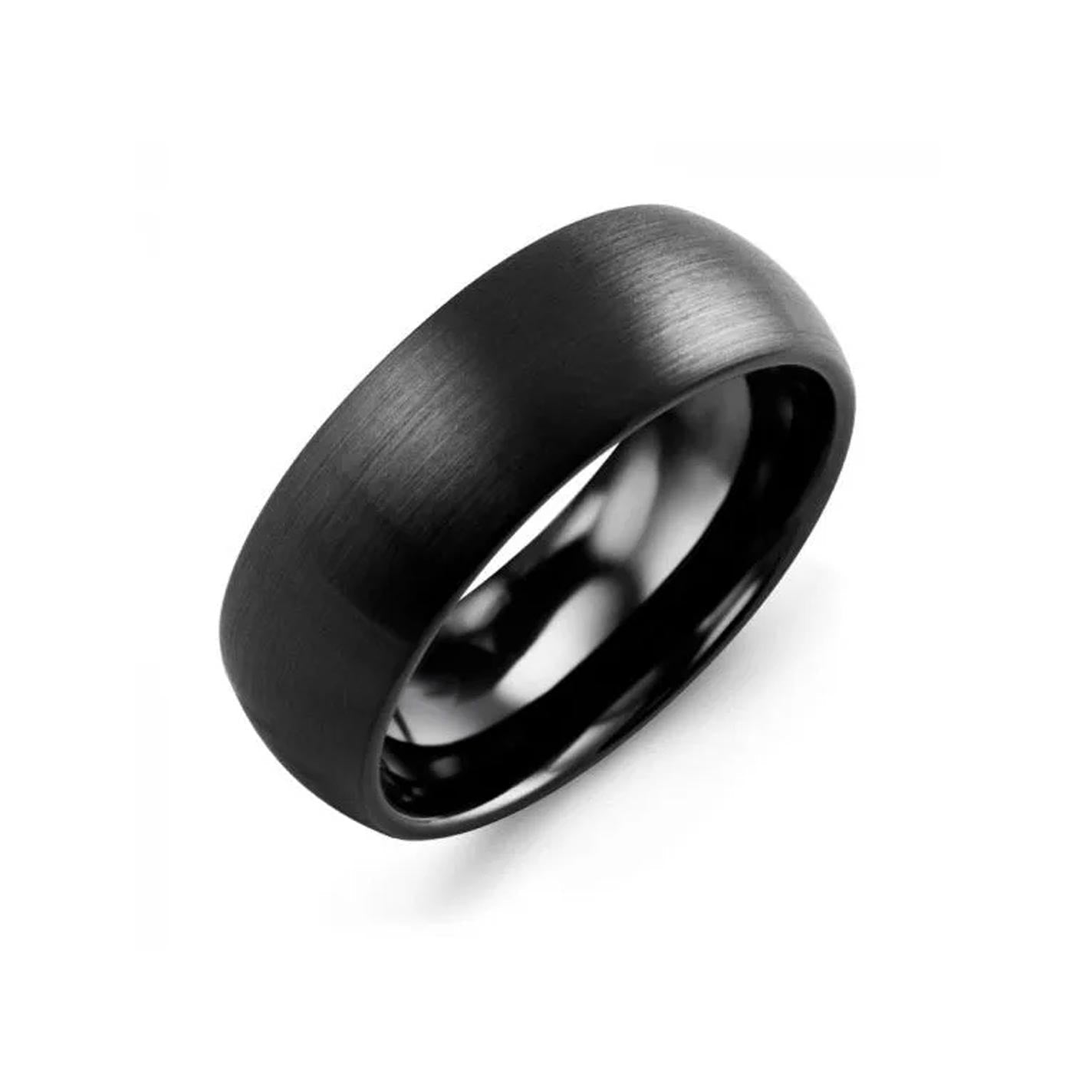 The Madani Classic Satin Finish Black Ceramic Wedding Band by Madani is showcased against a white backdrop. This modern piece of jewelry boasts a sleek, matte black design with a rounded band that subtly reflects light, emphasizing its polished finish.