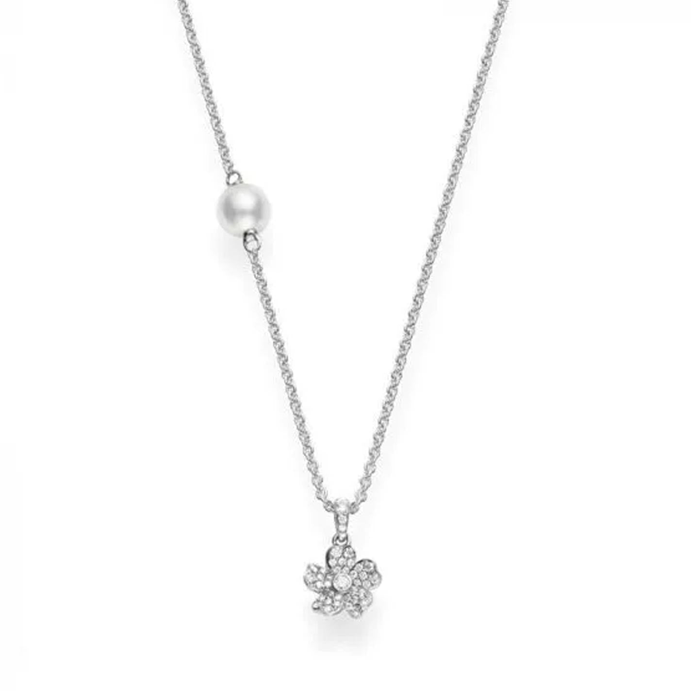 The Mikimoto Cherry Blossom necklace features an 18K white gold design adorned with a flower pendant encrusted with diamonds and complemented by a stationed Akoya cultured pearl, highlighting its elegance.