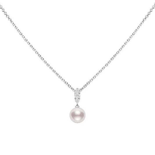 The Mikimoto Morning Dew necklace features an 18K white gold chain with a pendant showcasing an Akoya cultured pearl. It is elegantly attached by a polished loop embellished with tiny, sparkling diamonds, making it a chic addition to any outfit. The plain white background highlights its timeless elegance.