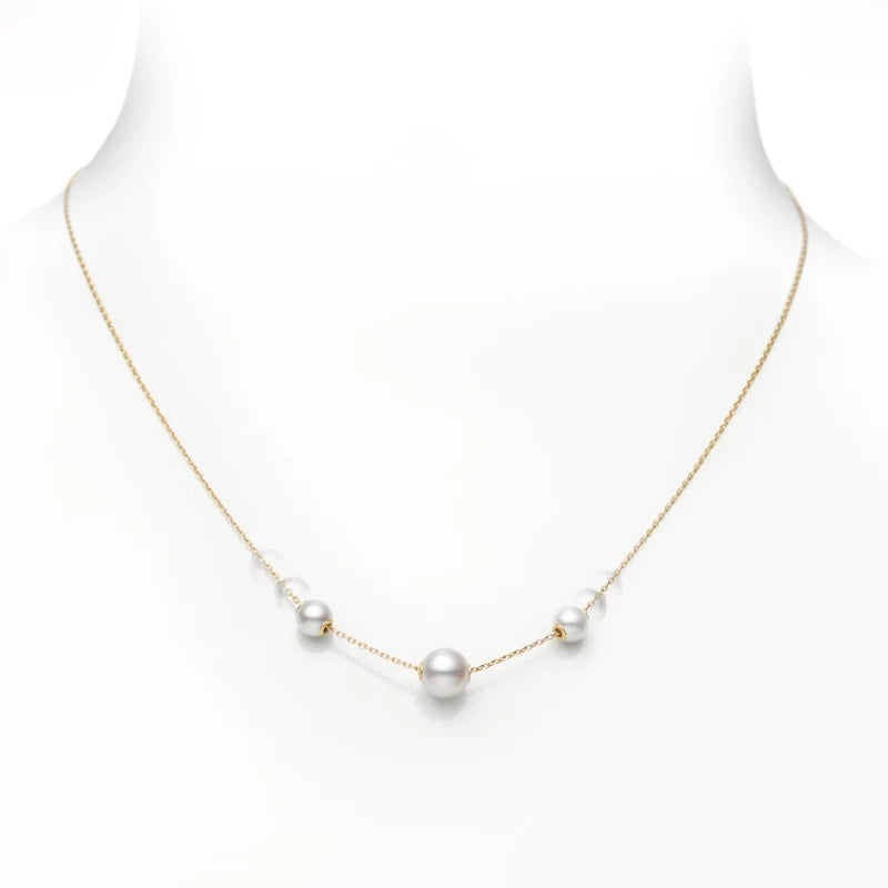 The Mikimoto Pearls In Motion 18K Yellow Gold Pearl Necklace Pendant by Mikimoto features five evenly spaced Akoya cultured pearls, elegantly presented on a white bust. This adjustable necklace embodies understated elegance and timeless sophistication.