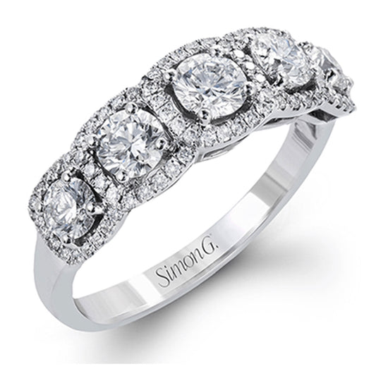 Introducing the Simon G. 18K White Gold Sapphire And Diamond Ring: This exquisite piece features five round sapphires, each encircled by a halo of smaller diamonds. The contemporary band showcases an engraving of "Simon G," adding a personal touch.