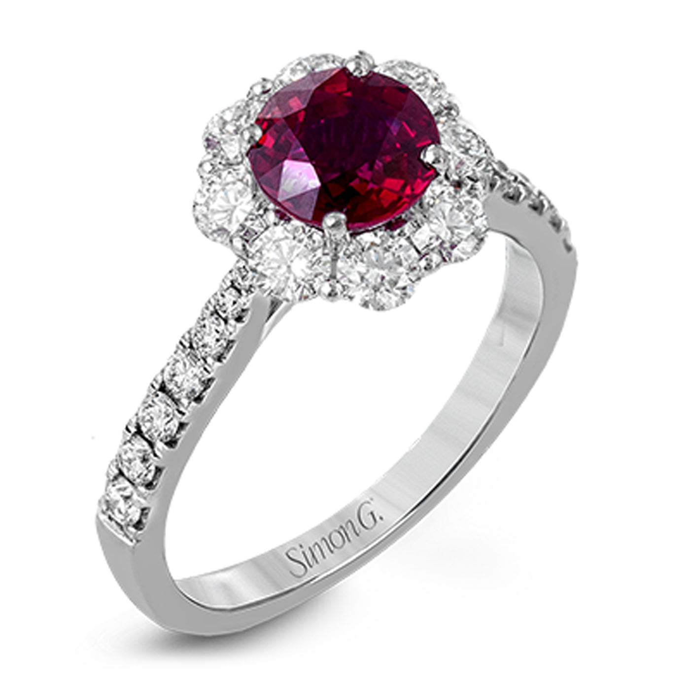 A breathtaking ring crafted from 18K white gold highlights a central round ruby, elegantly encircled by small, clear gemstones in a captivating floral design. The band is adorned with additional white diamonds, and the engraving "Simon G." embellishes the side.