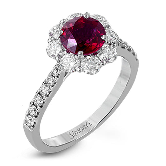 The Simon G 18K White Gold Ruby with Diamond Ring features a stunning large round ruby at its center, elegantly encircled by smaller clear diamonds in a floral design. The band is beautifully adorned with additional clear diamonds, enhancing its exquisite charm.