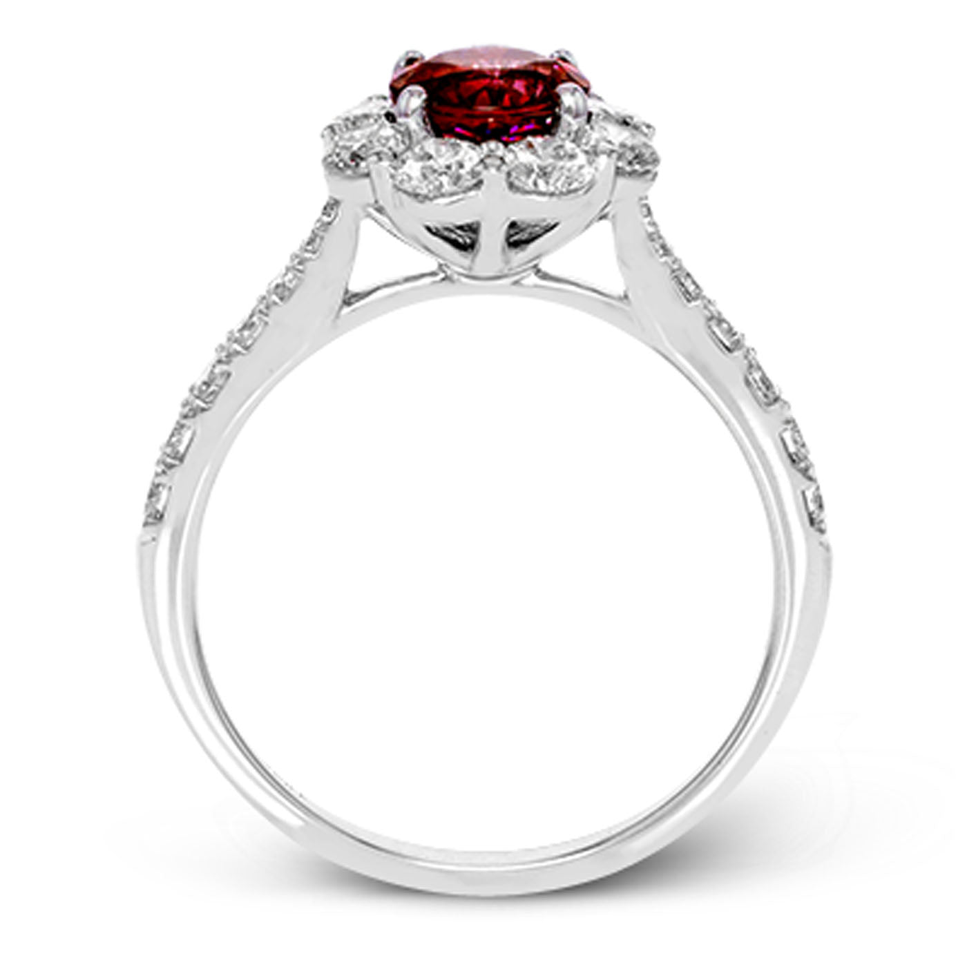 The Simon G. 18K White Gold Ruby with Diamond Halo Ring features a central round ruby surrounded by sparkling white diamonds embellishing the band and encircling the main gemstone. Its intricate design highlights a beautifully detailed floral motif setting, exemplifying expert metalwork.