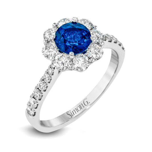 Introducing the Simon G. 18K White Gold Sapphire with Diamond Fashion Ring, beautifully crafted in white gold. It showcases a breathtaking large, round blue sapphire encircled by brilliant small clear diamonds. Additional small diamonds embellish the band, which is elegantly engraved with "Simon G.