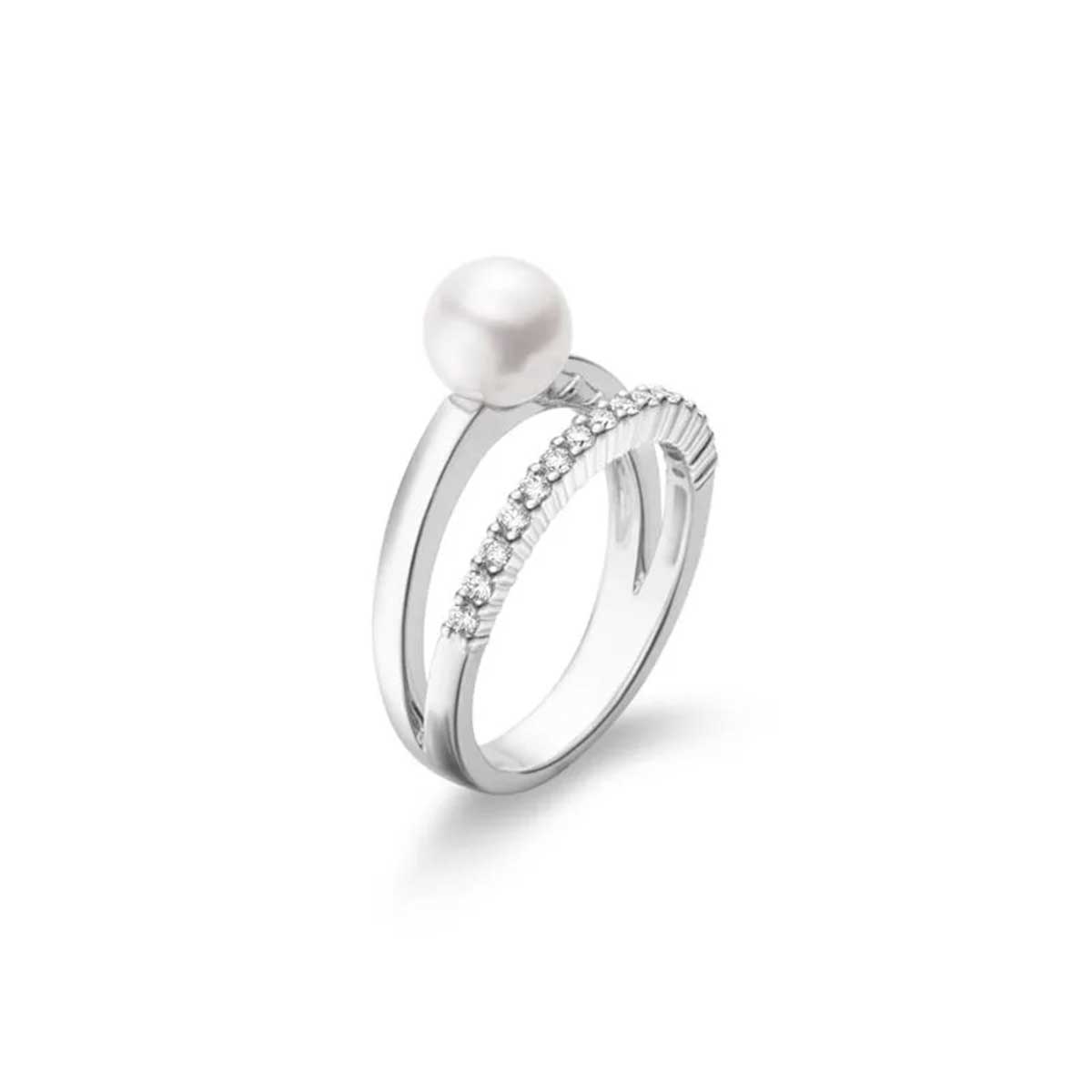 Introducing the Mikimoto 18K White Gold Diamond with Akoya Cultured Pearl Split Shank Ring by Mikimoto: This exquisite piece features a single cultured pearl elegantly complemented by a row of dazzling diamonds on one band. The modern design boasts clean lines and a sleek finish, enhanced by its 18 Karat white gold setting, all beautifully presented against a white background.