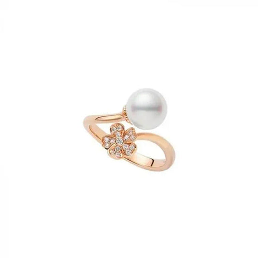 The Mikimoto Cherry Blossom 18K Rose Gold Diamond with Akoya Cultured Pearl Ring features an elegant open design, highlighting an Akoya cultured pearl on one side and a Cherry Blossom motif embellished with sparkling diamonds on the other. The exquisite piece, crafted by Mikimoto, is beautifully presented against a plain white background.