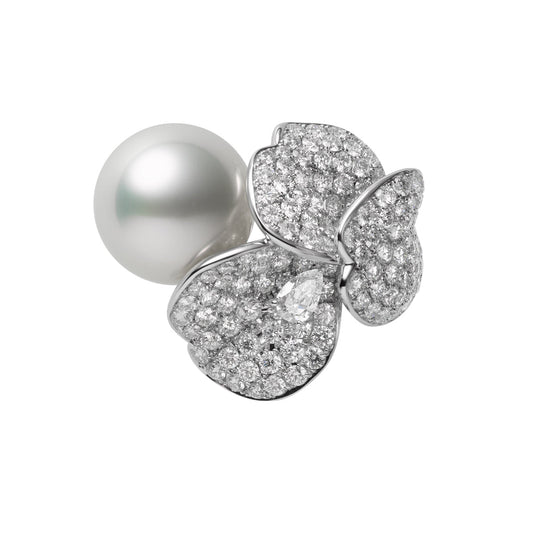 The Mikimoto Les Pétales Place Vendôme 18K White Gold Diamond with South Sea Pearl Ring is an exquisite piece featuring a large South Sea pearl at its center, surrounded by a delicate design of butterfly-shaped petals adorned with small, sparkling diamonds set in shimmering 18K white gold.