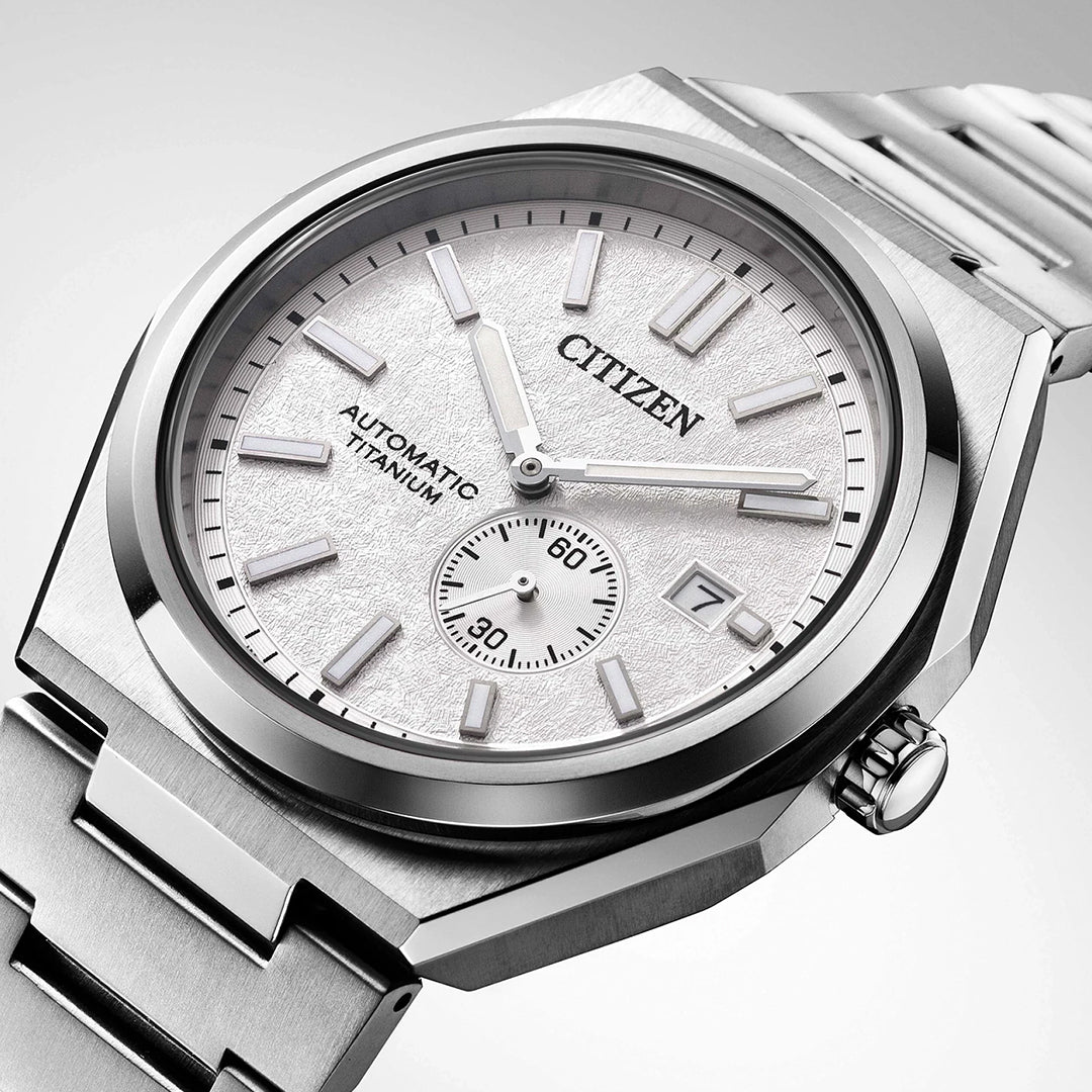 A close-up of the CITIZEN Zenshin Mechanical Automatic 40.5mm Watch, featuring a metallic silver band, textured white dial, silver hour markers, date display, and a subdial above the 6 o'clock position.