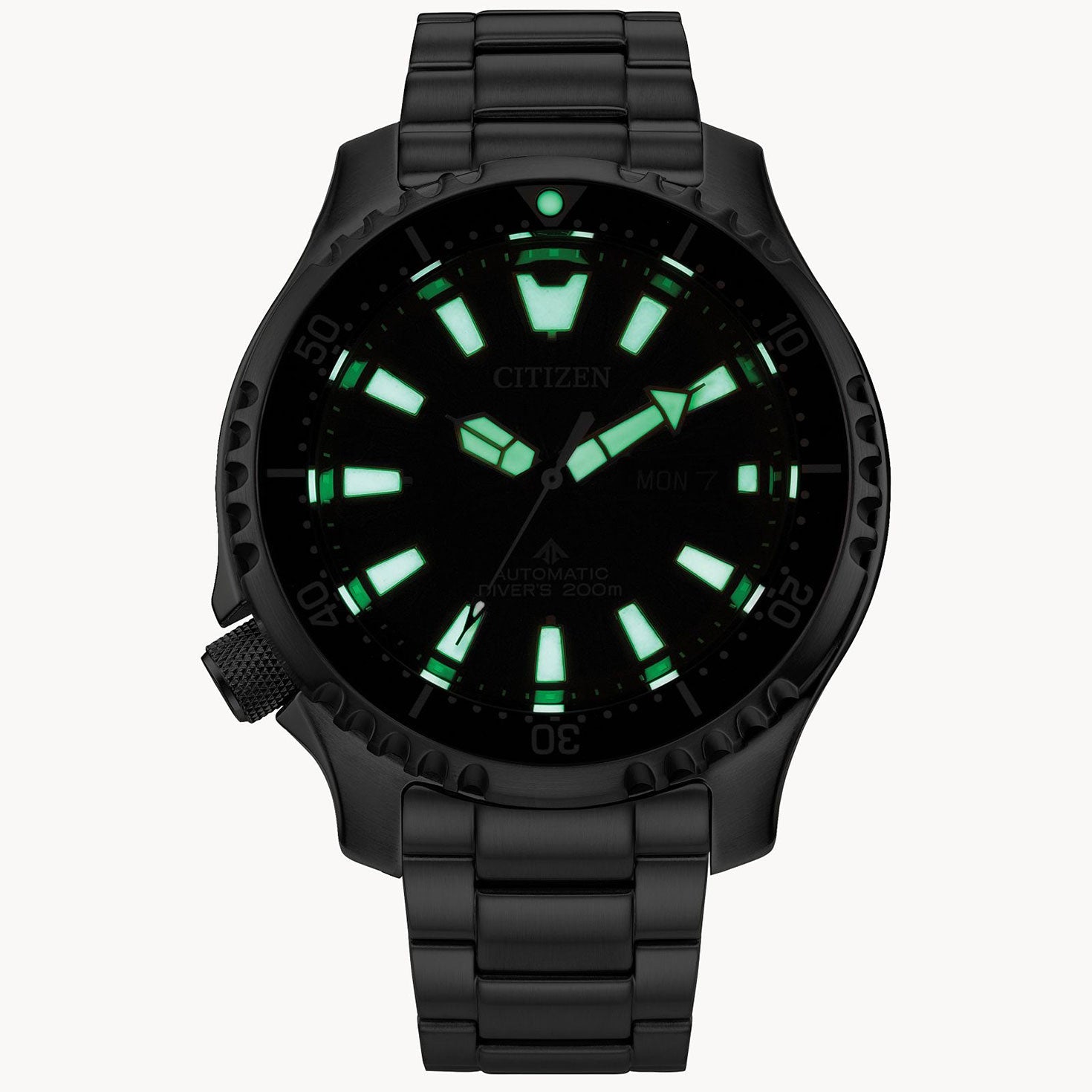 The CITIZEN Promaster Dive Automatic Mechanical 44mm Watch features luminescent green hour markers and hands on a dark dial, complemented by a rotating bezel and metal bracelet. It includes a day and date display at the three o'clock position and boasts water resistance up to 200 meters.